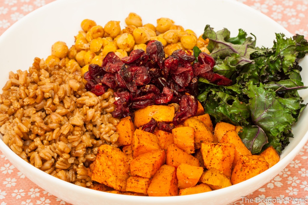 bowl with farro, kale and roasted sweet potato salad ingredients - kale, chickpeas, farro, sweet potato and cranberries