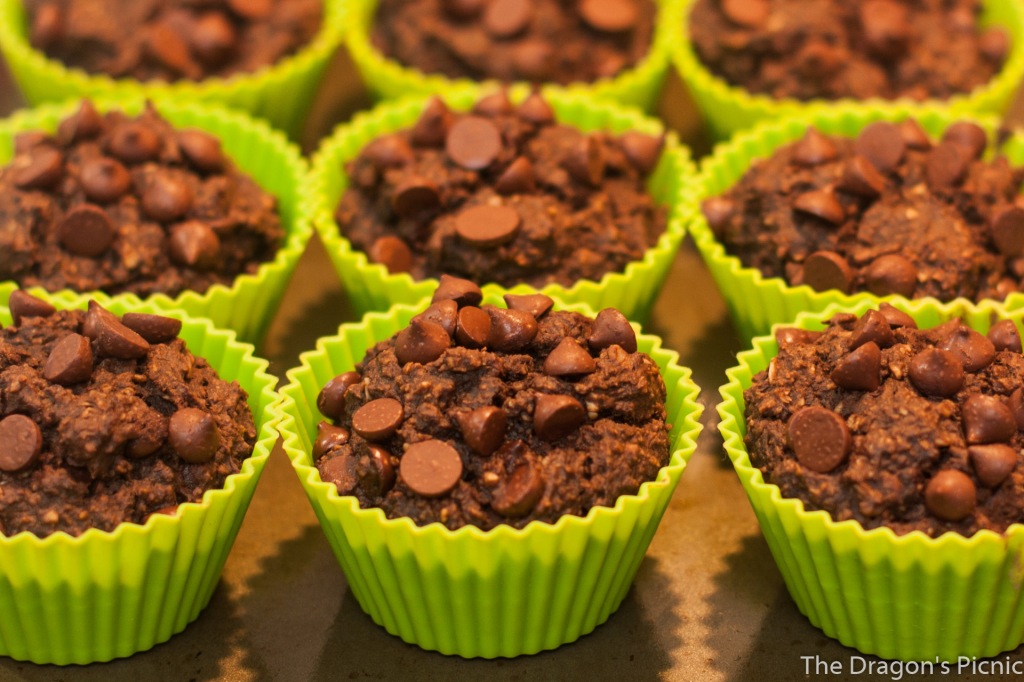 close up of several rows of chocolate pumpkin muffins in green muffin cases ready to bake